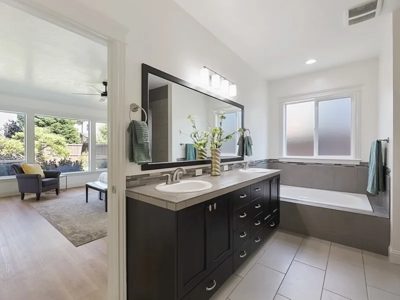 Remodeled master bathroom with double vanity and tiled soaking tub