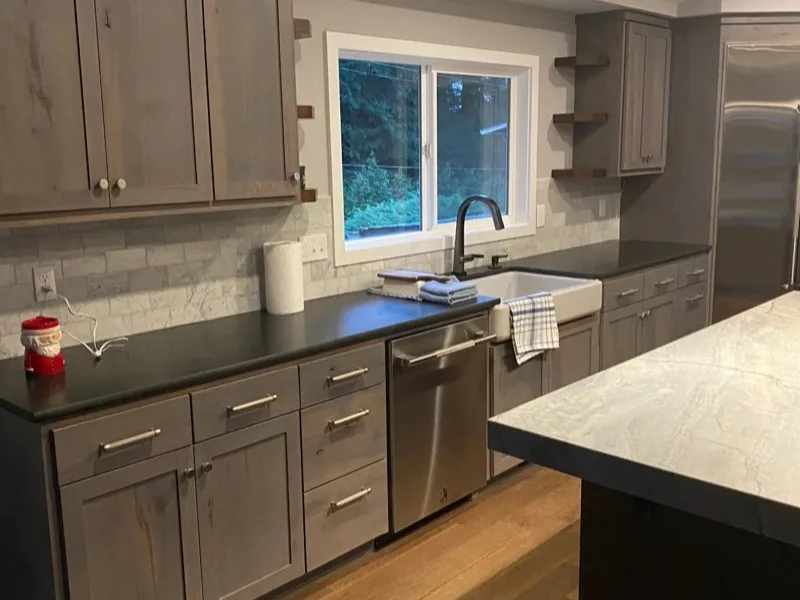 Remodeled kitchen with farmhouse sink and marble backsplash