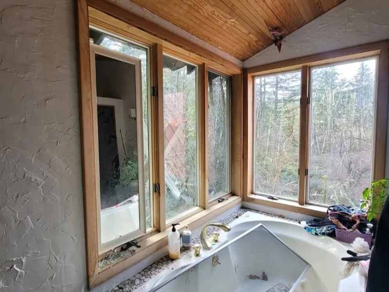 Before: bathroom with storm-broken windows and shattered glass